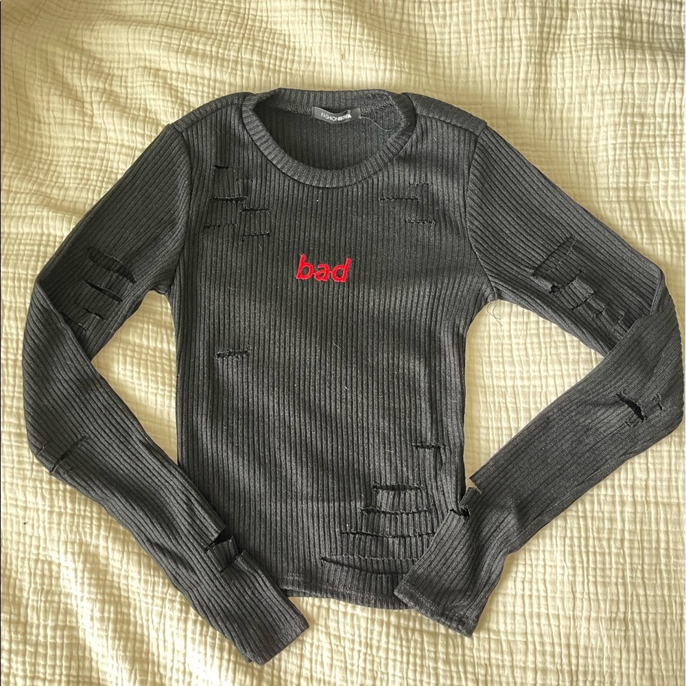 Black right sweater w/ small rips & “bad” on front. Fashionova size S